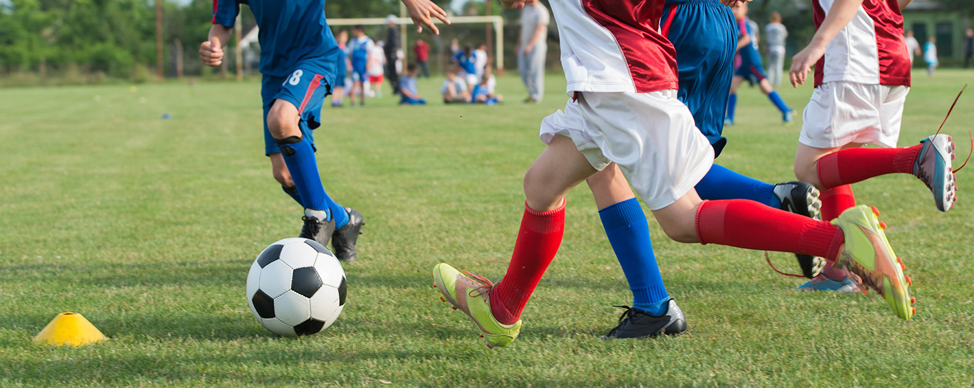 Players passing the ball into a striker playing high up the pitch